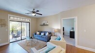 This well-appointed 2-bedroom, 3-bathroom residence in Columbia, SC offers a thoughtfully designed single-floor layout that maximizes comfort and functionality. The open-concept living and dining area is anchored by warm hardwood flooring, neutral tones, and a ceiling fan, with a sliding glass door that opens to a private balcony, inviting natural light throughout. The living room provides a welcoming atmosphere with generous seating space and a decorative wall shelf.

The kitchen is a standout feature, showcasing rich dark-stained cabinetry, granite countertops, a subway tile backsplash, stainless steel appliances, and a peninsula with bar seating — ideal for casual dining or entertaining. Adjacent to the kitchen, the dedicated dining area comfortably accommodates a round table for four.

Both bedrooms are carpeted and include ceiling fans. The primary bedroom connects directly to a private en-suite bathroom featuring granite vanity counters, dark cabinetry, tile flooring, and a tub-shower combination. A spacious walk-in closet with wire shelving provides ample storage. An in-unit laundry area with a stacked washer and dryer adds everyday convenience, completing this efficiently designed and move-in-ready home.