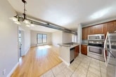 Located at 721 N Clinton St in Syracuse, NY, this thoughtfully designed 3-bedroom, 2-bathroom residence offers a well-appointed single-floor layout with a blend of modern finishes and industrial character. The open-concept living and kitchen area is a standout feature, showcasing warm hardwood flooring, exposed ventilation ductwork that adds an urban loft aesthetic, and a peninsula kitchen with granite countertops, warm wood cabinetry, stainless steel appliances including a refrigerator and dishwasher, and tile flooring. The living area is bathed in natural light from large sliding and picture windows, with a seamless flow to the private balcony offering open views of the surrounding Syracuse skyline and historic brick architecture. The three bedrooms are carpeted for comfort, each with ceiling fans and windows that invite natural light. The generously sized primary bedroom provides ample space for rest and relaxation. Five closets throughout the unit ensure abundant storage. Three hallways connect the rooms efficiently across the single floor. The balcony is a particular highlight, featuring a metal railing and expansive open-air views of the city neighborhood, perfect for enjoying the outdoors.