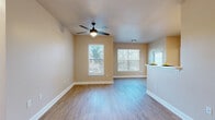 This single-story, 2-bedroom, 2-bathroom residence offers a functional and comfortable layout designed for everyday living. The open-concept living and dining area is bright and welcoming, featuring warm hardwood-style flooring, neutral beige walls, and multiple windows with blinds that allow ample natural light to fill the space. A ceiling fan overhead adds both comfort and practicality to the room.

The galley-style kitchen is well-equipped with rich wood cabinetry, light countertops, white appliances including a range and dishwasher, and a double sink. A pass-through counter connects the kitchen to the living area, enhancing the open feel. Adjacent to the kitchen is a dedicated laundry closet for added convenience.

Both bedrooms are generously proportioned, each featuring hardwood-style flooring, ceiling fans, and windows that invite natural light. Each bedroom is paired with its own walk-in closet outfitted with wire shelving systems offering versatile storage options.

The two bathrooms are well-designed; one features a tub-shower combination with grab bars and warm wood vanity cabinetry, while the other includes a walk-in shower with grab bars and a wide double-sink vanity with a large mirror. Throughout the residence, a cohesive warm neutral palette and consistent flooring create a unified and inviting ambiance.