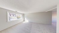 Located at 200 Bedford Rd in Woburn, MA, this one-bedroom, one-bathroom unit offers a well-organized single-floor layout with a clean, neutral aesthetic throughout. The living area is generously sized, featuring soft wall-to-wall carpeting, light gray walls, and a textured ceiling. A wide double window floods the space with natural light, creating a bright and open atmosphere.

The kitchen has been thoughtfully updated with crisp white shaker-style cabinetry, white quartz countertops, and a full suite of stainless steel appliances, including a gas range, over-the-range microwave, dishwasher, and refrigerator. Light wood-look flooring and dual windows give the kitchen a clean, airy feel, while ample cabinet storage adds practical functionality.

The spacious primary bedroom features recessed lighting, a natural-light window, and two side-by-side closets, offering generous storage. The soft carpeting continues throughout, maintaining a consistent and comfortable feel. The bathroom is finished with a full tub and shower combination, white subway tile surround, and chrome fixtures, delivering a clean and functional space.

The unit's layout, visible in the dollhouse view, reflects an efficient and straightforward floor plan suited for comfortable everyday living.