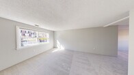 Located at 200 Bedford Rd in Woburn, MA, this one-bedroom, one-bathroom unit offers a well-organized single-floor layout with a clean, neutral aesthetic throughout. The living area is generously sized, featuring soft wall-to-wall carpeting, light gray walls, and a textured ceiling. A wide double window floods the space with natural light, creating a bright and open atmosphere.

The kitchen has been thoughtfully updated with crisp white shaker-style cabinetry, white quartz countertops, and a full suite of stainless steel appliances, including a gas range, over-the-range microwave, dishwasher, and refrigerator. Light wood-look flooring and dual windows give the kitchen a clean, airy feel, while ample cabinet storage adds practical functionality.

The spacious primary bedroom features recessed lighting, a natural-light window, and two side-by-side closets, offering generous storage. The soft carpeting continues throughout, maintaining a consistent and comfortable feel. The bathroom is finished with a full tub and shower combination, white subway tile surround, and chrome fixtures, delivering a clean and functional space.

The unit's layout, visible in the dollhouse view, reflects an efficient and straightforward floor plan suited for comfortable everyday living.