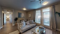 This single-floor residence showcases a thoughtfully designed open-concept layout that seamlessly connects the main living areas. The living room serves as the centerpiece of the home, featuring wood-style flooring, a ceiling fan, and French doors that invite natural light while providing outdoor access. A dedicated dining area sits adjacent to the living space, creating a natural flow ideal for entertaining.

The kitchen is outfitted with a two-tone cabinetry design — dark lower cabinets contrasted by crisp white upper cabinets — complemented by a subway tile backsplash and stainless steel appliances. A central island with a built-in sink and bar seating adds both functionality and style, with pendant lighting overhead.

The bedrooms offer plush carpeting, generous closet storage, and large windows that fill each room with natural light. The neutral color palette creates a calm, versatile atmosphere throughout.

Two full bathrooms serve the residence. One features a tub-shower combination with a dark vanity and tile flooring, while the second bathroom includes a vanity with ample counter space, open shelving for storage, and coordinating tile floors. Together, the rooms present a cohesive, contemporary aesthetic throughout.
