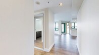 Located on the 9th floor at 150 Keith Rd E in North Vancouver, this two-bedroom, one-bathroom unit offers a well-designed layout with modern finishes throughout. Light wood laminate flooring runs continuously across the living spaces, enhancing the bright and airy atmosphere created by large floor-to-ceiling windows.

The open-concept kitchen features white shaker cabinetry, a glass tile backsplash, quartz countertops, and a full suite of stainless steel appliances including a dishwasher, range, microwave, and refrigerator. A central island provides additional workspace and storage. The living room is generously proportioned, bathed in natural light, and opens directly onto a private balcony with glass railings, offering sweeping views of the North Vancouver cityscape, lush tree canopy, and the waters beyond.

The primary bedroom is a comfortable size and includes mirrored sliding closet doors and direct access to the balcony. The second bedroom also features mirrored closet doors and benefits from natural light. The bathroom is finished with classic white subway tile, polished stone-look floor tile, a dark-toned vanity with ample storage, and chrome fixtures. This unit combines functional design with elevated finishes in a prime North Vancouver location.