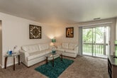 This single-floor residence offers a thoughtfully organized layout that balances comfort and functionality across its key living areas. The living room serves as the heart of the home, featuring wall-to-wall carpeting, a textured ceiling, and a large sliding glass door that opens to a private balcony overlooking lush greenery, filling the space with natural light and outdoor views.

The galley-style kitchen is efficiently designed with dark espresso cabinetry, granite-style countertops, a double stainless steel sink, and white appliances including a refrigerator, electric range, and dishwasher. Light tile flooring completes the clean, practical aesthetic.

The primary bedroom is generously sized, featuring soft carpeting and direct access to a walk-in closet and an en-suite bathroom. The second bedroom also offers comfortable proportions, carpeted flooring, and a window that brings in natural light.

Two bathrooms serve the residence: one full bathroom with a tub/shower combination, dark cabinetry, and a single vanity sink, and a second bathroom featuring a shower with a curtain, tile flooring, and straightforward fixtures. Both bathrooms maintain a clean, neutral palette. Overall, the residence offers a warm, inviting atmosphere with cohesive, neutral tones throughout.