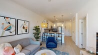 Located at 411 Flemington Rd in Chapel Hill, NC, this single-story residence offers a thoughtfully designed open-concept layout that seamlessly connects the living, dining, and kitchen areas. Light wood-style flooring flows throughout the space, complemented by crisp white walls and an abundance of natural light.

The kitchen is a standout feature, boasting white upper cabinetry paired with dark lower cabinets, a gray tile backsplash, granite countertops, stainless steel appliances, and pendant lighting over a breakfast bar with seating. Open shelving adds both function and visual interest.

The living area is bright and inviting, highlighted by floor-to-ceiling glass doors that open onto a private balcony with tree-lined views. This seamless indoor-outdoor connection enhances the sense of openness throughout the space.

The bedrooms are generously sized, each offering large windows that allow natural light to fill the rooms. Ceiling fans provide added comfort, and the primary bedroom connects directly to a well-appointed bathroom featuring a granite-topped vanity with dark cabinetry.

Additional highlights include a spacious walk-in closet with wire shelving systems, providing ample storage. The overall ambiance is modern and welcoming, with a clean, contemporary aesthetic throughout.