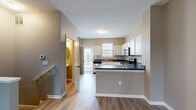 Located at 6460 Chelsea Glen Dr in Columbus, Ohio, this three-story home offers a practical and well-organized layout across its floors. The ground level features an attached garage with a motorized door opener, concrete flooring, and direct interior access — providing secure and convenient parking or additional storage space. The main living level serves as the heart of the home, where an open-concept kitchen and living room create a cohesive, functional space. The kitchen is equipped with stainless steel appliances, including a full-size refrigerator, and includes a dedicated nook housing a stacked washer and dryer for in-unit laundry convenience. Light wood-look flooring flows throughout this level, complemented by neutral warm-toned walls and natural light from windows with blinds. The upper floor houses both bedrooms and two full bathrooms. The generously sized primary bedroom offers carpeted flooring and ample natural light. The second bedroom also features carpet and multiple windows. Both bathrooms are well-appointed with white vanities, wood-look flooring, and clean, neutral finishes — one featuring a walk-in glass shower and the other a tub/shower combination. Staircases connect all three levels, making this home an efficient and comfortable multi-floor residence.