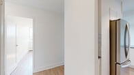 Located at 3390 Keele Street in Toronto's York district, this 2-bedroom, 1-bathroom unit offers a clean, modern living environment with a bright and functional layout. Light-toned hardwood flooring runs consistently throughout the space, complementing the crisp white walls and creating a cohesive, airy feel.

The open-concept living area is generously sized, featuring large floor-to-ceiling windows that flood the room with natural light and provide expansive treetop views. The kitchen is efficiently designed with white cabinetry, a subway tile backsplash, a stainless steel sink, and a dark-topped island that doubles as additional prep and storage space, seamlessly connecting to the living area.

Both bedrooms are well-proportioned and bright, each benefiting from large windows that frame pleasant outdoor views. The primary bedroom includes a mirrored sliding-door closet, offering practical storage. Baseboard heating units are present throughout, ensuring year-round comfort.

The bathroom is finished in a clean, classic style with white subway tile surrounding the bathtub and shower, a white vanity, a large mirror, and neutral stone-look tile flooring. The overall design of the unit is minimal and move-in ready, offering a comfortable and functional living space in a well-connected Toronto neighbourhood.