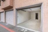 Located at 854 Vine St in Oceanside, California, this single-floor space consists of a garage and an adjoining room. The garage features a standard roll-up overhead door with an automatic opener track, offering direct access to the driveway and street beyond. The interior is finished with smooth white walls and a concrete floor, providing a clean, functional layout suitable for vehicle storage or a workshop setting. Natural light filters in through the open garage door, offering views of the surrounding greenery outside. Attached to the garage is a secondary room accessible through a doorway, distinguished by its exposed cinder block wall construction. This additional space shares the same concrete flooring and white-painted walls, making it a versatile area that could serve as storage, a utility room, or a workspace. The straightforward, utilitarian design of the overall space prioritizes functionality, with clean lines and minimal detailing throughout. The layout and construction suggest a solid, durable build well-suited for a variety of practical uses in the Oceanside, CA area.