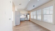 Located at 3001 Cypress Lake Rd in North Charleston, SC, this one-bedroom, one-bathroom unit offers a thoughtfully designed layout that maximizes every square foot. The open-concept living and kitchen area is immediately impressive thanks to dramatic vaulted ceilings with track lighting, creating a sense of volume and openness well beyond the unit's compact footprint. Light wood-style flooring runs throughout, lending a clean, cohesive aesthetic to the entire space.

The kitchen is well-appointed with gray shaker-style cabinetry, white countertops, a full suite of stainless steel appliances including a refrigerator, range, microwave, and dishwasher, as well as a built-in wine rack above the refrigerator. Large windows with white blinds flood the living area with natural light.

The bedroom is a bright, comfortable retreat featuring a ceiling fan, dual windows, and continued wood-style flooring. It connects to a dedicated walk-in closet outfitted with multi-tier wire shelving for ample storage. The bathroom includes a gray vanity with a white countertop, a framed mirror, and a glass-enclosed walk-in shower. Clean white walls and neutral finishes throughout give the unit a modern, move-in-ready appeal.