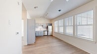 Located at 3001 Cypress Lake Rd in North Charleston, SC, this one-bedroom, one-bathroom unit offers a thoughtfully designed layout that maximizes every square foot. The open-concept living and kitchen area is immediately impressive thanks to dramatic vaulted ceilings with track lighting, creating a sense of volume and openness well beyond the unit's compact footprint. Light wood-style flooring runs throughout, lending a clean, cohesive aesthetic to the entire space.

The kitchen is well-appointed with gray shaker-style cabinetry, white countertops, a full suite of stainless steel appliances including a refrigerator, range, microwave, and dishwasher, as well as a built-in wine rack above the refrigerator. Large windows with white blinds flood the living area with natural light.

The bedroom is a bright, comfortable retreat featuring a ceiling fan, dual windows, and continued wood-style flooring. It connects to a dedicated walk-in closet outfitted with multi-tier wire shelving for ample storage. The bathroom includes a gray vanity with a white countertop, a framed mirror, and a glass-enclosed walk-in shower. Clean white walls and neutral finishes throughout give the unit a modern, move-in-ready appeal.