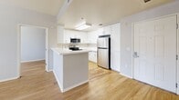 Located at 2020 Kittredge St, Unit 410, in the heart of Berkeley, CA, this 2-bedroom, 1-bathroom unit offers a thoughtfully designed layout across a single floor. Light-toned hardwood-style flooring runs throughout the entire unit, creating a clean and cohesive aesthetic.

The open-concept kitchen is a standout feature, boasting white shaker cabinetry with ample storage, white quartz countertops, a center island with a built-in sink, and a full suite of stainless steel appliances including a range, microwave, and refrigerator. The kitchen flows seamlessly into the combined dining and living area, which is brightened by natural light through double windows.

Both bedrooms are well-proportioned with windows fitted with blinds that allow for adjustable natural light. The primary bedroom includes a dedicated walk-in closet, while the secondary bedroom features a sliding-door closet. An additional closet provides further storage options throughout the unit.

The bathroom is clean and functional, featuring a white vanity, a full bathtub with shower, and hardwood-style flooring consistent with the rest of the unit. Neutral gray walls throughout create a modern, move-in-ready feel ideal for comfortable urban living.