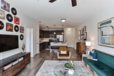 Located at 120 W Trinity Place in Decatur, Georgia, this single-floor residence offers a thoughtfully designed open-concept layout that seamlessly connects the kitchen, dining, and living areas. The kitchen is a standout feature, showcasing dark espresso cabinetry that extends to the ceiling, a classic subway tile backsplash, stainless steel appliances, and a large center island with a white quartz countertop and pendant lighting overhead. Track lighting adds a modern industrial touch.

The living area is bright and spacious, benefiting from large windows that invite natural light and views of the surrounding Decatur neighborhood. Durable wood-style flooring flows throughout the main living spaces, while ceiling fans provide comfort in both the living room and bedrooms.

Two well-sized bedrooms each feature plush carpet, ceiling fans, and windows with outdoor views. Each bedroom is served by its own bathroom, both finished with large-format tile flooring, white vanities with ample drawer storage, and dark-framed mirrors. Walk-in and reach-in closet options provide generous storage.

The overall ambiance is contemporary and welcoming, combining clean architectural lines with warm finishes throughout.