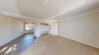 Located at 3309 Cowley Way in San Diego's 92117 zip code, this single-story home offers a well-organized layout with a variety of comfortable living spaces. The main living area features a combination of plush carpet and hardwood-style flooring, crown molding, and a tray ceiling that adds architectural character. A large window with vertical blinds fills the room with natural light, while a built-in shelving and desk unit provides practical storage and workspace. A ceiling fan adds comfort to the adjoining area, which also benefits from an abundance of natural light. The kitchen is well-appointed with white shaker-style cabinetry, granite countertops, a stainless steel gas range, a stainless steel dishwasher, and a double-basin sink with a modern faucet — all complemented by wood-style flooring. The bedrooms offer carpeted floors and generous natural light through windows dressed with vertical blinds; one bedroom includes mirrored sliding closet doors. The bathroom is clean and functional, featuring a pedestal sink, a tiled shower-tub combination, a medicine cabinet with mirror, and a window that brings in natural light. Throughout the home, a neutral color palette and consistent finishes create a cohesive and inviting atmosphere.