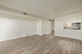 This two-story home is thoughtfully laid out across two levels, offering a comfortable and functional living environment. The main level features a bright living area with light wood-look flooring and a sliding glass door fitted with vertical blinds that opens to an outdoor patio, filling the space with natural light and providing easy access to the exterior. A hallway connects the main living spaces, with carpeted stairs leading to the upper level.

The kitchen is well-equipped with white cabinetry, light-toned countertops, and a full suite of stainless steel appliances, including a gas range, over-the-range microwave, dishwasher, and refrigerator. Light tile flooring and a window with vertical blinds contribute to the kitchen's bright, clean aesthetic.

Upstairs, the bedrooms feature plush carpeting and exposed wood beam ceilings that add architectural character. Each bedroom includes sliding closet doors for ample storage, and windows offer outdoor views. The bathroom is finished with a white vanity, speckled countertop, and brushed nickel hardware. Throughout the home, neutral tones and consistent finishes create a cohesive and move-in-ready atmosphere.