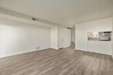 This two-story home is thoughtfully laid out across two levels, offering a comfortable and functional living environment. The main level features a bright living area with light wood-look flooring and a sliding glass door fitted with vertical blinds that opens to an outdoor patio, filling the space with natural light and providing easy access to the exterior. A hallway connects the main living spaces, with carpeted stairs leading to the upper level.

The kitchen is well-equipped with white cabinetry, light-toned countertops, and a full suite of stainless steel appliances, including a gas range, over-the-range microwave, dishwasher, and refrigerator. Light tile flooring and a window with vertical blinds contribute to the kitchen's bright, clean aesthetic.

Upstairs, the bedrooms feature plush carpeting and exposed wood beam ceilings that add architectural character. Each bedroom includes sliding closet doors for ample storage, and windows offer outdoor views. The bathroom is finished with a white vanity, speckled countertop, and brushed nickel hardware. Throughout the home, neutral tones and consistent finishes create a cohesive and move-in-ready atmosphere.