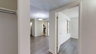 This single-floor, 3-bedroom, 1-bathroom home offers a thoughtfully designed layout that maximizes its compact footprint. The living room serves as the heart of the home, featuring rich hardwood-style flooring, a textured ceiling, a classic fireplace with a white mantel, and a pendant light fixture. Natural light fills the space through a large window with views of lush greenery outside, creating a bright and welcoming atmosphere.

The kitchen is efficiently designed, showcasing white flat-panel cabinetry that extends to the ceiling for ample storage, dark granite countertops, a stainless steel gas range with an over-the-range microwave, and a white dishwasher. Light-toned tile flooring completes the clean, modern aesthetic.

A hallway connects the living areas to the three bedrooms, each finished with hardwood-style flooring and neutral white walls that allow for versatile use. The primary bedroom is generously sized and benefits from abundant natural light. A dedicated walk-in closet features built-in shelving and hanging rods, providing excellent storage capacity.

The bathroom is finished with tile flooring and includes a full tub-shower combination with a sliding glass door and chrome fixtures. Throughout the home, the consistent use of neutral tones, hardwood-style flooring, and textured ceilings creates a cohesive and clean aesthetic.