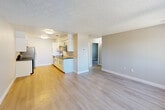 Located at 730 Via De Luna in Corona, CA, this two-bedroom, one-bathroom single-floor residence offers a practical and well-designed layout with a clean, modern aesthetic throughout. Light wood-look flooring runs continuously through the living spaces, complemented by neutral gray walls, crisp white baseboards, and textured ceilings that give each room a cohesive feel.

The open-concept living and dining area is bright and airy, with large windows dressed in vertical blinds that allow generous natural light to filter in. The space flows seamlessly into the galley-style kitchen, which features white shaker cabinetry with black hardware, gray countertops, a subway tile backsplash, and stainless steel appliances including a range, refrigerator, and dishwasher — providing a functional and stylish cooking environment.

Both bedrooms are comfortably sized and finished with the same light flooring and neutral palette. The primary bedroom offers a spacious feel, while the second bedroom includes dual reach-in closets with built-in rods for ample storage.

The bathroom is neatly appointed with a white vanity featuring black hardware, a gray countertop, and a tiled tub-and-shower combination, maintaining the home's consistent modern design language throughout.