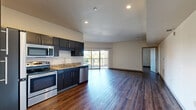 Located at 2645 Railroad Street in Pittsburgh's vibrant Strip District, this well-appointed 2-bedroom, 2-bathroom residence offers a thoughtfully designed open-concept layout. Rich hardwood-style flooring flows consistently throughout the entire unit, creating a cohesive and modern aesthetic.

The combined kitchen and living area serves as the heart of the home. The kitchen is outfitted with dark espresso cabinetry, granite-look countertops, and a full suite of stainless steel appliances including a refrigerator, electric range, microwave, and dishwasher. Recessed lighting brightens the space, while a sliding glass door leads to a private balcony, inviting natural light into the living area.

Both bedrooms are generously sized, featuring neutral walls and windows that offer outdoor views of the surrounding neighborhood. Three closets provide ample storage throughout the unit. The two bathrooms each include a tub-shower combination with a curved curtain rod, granite-look vanity tops, and dark cabinetry that mirrors the kitchen's design.

Additional conveniences include an in-unit laundry room, a utility room, and dedicated storage. The overall ambiance is clean, contemporary, and move-in ready, making this an ideal residence in one of Pittsburgh's most dynamic neighborhoods.