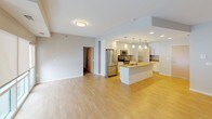 This single-floor residence offers a thoughtfully designed layout that balances comfort and functionality throughout. The open living area features light hardwood-style flooring and neutral wall tones, providing a clean, versatile backdrop with track lighting overhead. The kitchen is a standout space, equipped with white shaker-style cabinetry, stainless steel appliances, warm granite countertops, a large central island, pendant lighting, and a convenient walk-in pantry — all set over the same light hardwood-style flooring that ties the living spaces together. The primary bathroom is generously sized with dual vanities topped with granite counters, white cabinetry, and a glass-enclosed walk-in shower. A secondary full bathroom mirrors the same finishes, featuring a granite-topped vanity and a full shower-tub combo. The bedrooms are carpeted for warmth and comfort, with roller shades on the windows that allow for adjustable natural light. A spacious walk-in closet with wire shelving provides ample, well-organized storage. Throughout, the space maintains a consistent, modern aesthetic with neutral tones, clean lines, and quality finishes that create a bright and welcoming atmosphere.