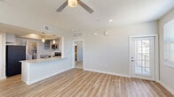 Located at 5222 Shadydell Dr in Fort Worth, TX, this two-story, 2-bedroom, 2-bathroom home offers a well-organized layout spread across two levels. The ground level houses an attached garage with an automatic opener, while the main living areas occupy the upper floor. Carpeted stairs with a clean white handrail lead up to the primary living space, where light wood-style flooring flows throughout the open-concept dining room, kitchen, and living room. The living area is bright and airy, featuring ceiling fans and multiple windows with blinds that invite natural light. The kitchen is equipped with stainless steel appliances including a range, microwave, and dishwasher, complemented by granite countertops, gray cabinetry, and a peninsula with a sink. Both bedrooms are carpeted and include ceiling fans and windows, with the spacious primary bedroom offering generous closet space and an en-suite bathroom. The bathrooms feature wood-look flooring and direct closet access. A dedicated laundry room includes a top-load washer and dryer. A balcony provides additional outdoor space, completing this functional and modern home.