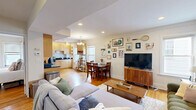 Located in the desirable Brookline neighborhood, this three-bedroom, two-bathroom residence offers a well-designed single-floor layout with a warm and inviting character throughout. Hardwood floors run continuously across the living spaces, lending cohesion and warmth to the home.

The living room is a standout space, featuring a patterned accent wall, recessed lighting, and natural light from street-facing windows. The kitchen is outfitted with light maple cabinetry, dark granite countertops, stainless steel appliances including a dishwasher and refrigerator, and recessed lighting overhead.

The primary bedroom is generously proportioned, featuring a corner window arrangement that fills the room with natural light and offers views of the surrounding neighborhood. The second bedroom showcases a striking exposed brick accent wall, adding architectural character and texture. The third bedroom is a cozy, well-lit space with a window overlooking greenery.

The two bathrooms differ in style: one features warm-toned tile flooring with a pedestal sink, while the other includes a vanity with cabinet storage, tile flooring, and a shower-tub combination. A connecting hallway ties all rooms together efficiently, completing this functional and characterful Brookline residence.