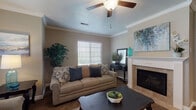 This single-floor residence offers a thoughtfully designed layout with a comfortable blend of functional spaces and classic finishes. The living room serves as the heart of the home, highlighted by a white-mantled fireplace with tile surround, crown molding, a ceiling fan, and a window fitted with plantation shutters that invite natural light. The kitchen is well-equipped with rich wood cabinetry, light stone countertops, white appliances, a central island with bar seating, and wood-look flooring — providing ample workspace and storage. A dedicated dining area sits adjacent to the kitchen, ideal for everyday meals. The bedrooms feature plush carpeting, generous natural light through shuttered windows, and access to closet space, offering restful and private retreats. The bathrooms are finished with wood-toned cabinetry, stone-look countertops, and tub-shower combinations, with wood-look flooring adding a cohesive touch. Throughout the residence, warm neutral wall tones and consistent trim details create a unified and inviting atmosphere, making this a comfortable and well-balanced living space.