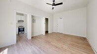 Located at 147 N New Hampshire Ave in Los Angeles' vibrant Koreatown neighborhood, this single-story, one-bedroom, one-bathroom unit offers a thoughtfully arranged and efficient layout. Light-toned laminate wood flooring runs throughout the space, creating a clean and cohesive aesthetic.

The main living area is an open, airy room bathed in natural light, featuring a sleek black ceiling fan and a neutral white color palette that enhances the sense of space. The front entry door opens directly into this inviting room, which connects seamlessly to the kitchen and bedroom hallway.

The kitchen is well-equipped with crisp white shaker-style cabinetry, a stainless steel sink beneath a window, light countertops, and a gas range with overhead ventilation — providing a functional and bright cooking space.

The spacious primary bedroom is a generous retreat, featuring its own ceiling fan, a large window that allows ample natural light, and a connected closet for storage. A hallway links the bedroom to the full bathroom, which is outfitted with floor-to-ceiling white tile surrounding a clean bathtub/shower combination.

The unit's efficient design makes excellent use of every square foot, offering a practical and move-in-ready home in a prime Los Angeles location.