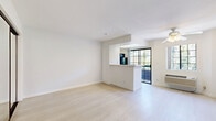 Located on the third floor at 7282 Franklin Ave in the heart of Hollywood, Los Angeles, this one-bedroom, one-bathroom unit offers a clean, modern aesthetic throughout. Light-toned wood-style flooring runs continuously across the entire space, creating a cohesive and airy feel.

The open living area is bright and functional, featuring a ceiling fan overhead and a wall-mounted air conditioning unit. A pass-through kitchen counter separates the cooking area from the main living space, with a refrigerator and access to a window that brings in natural light. Black-framed sliding glass doors lead to an outdoor area, further enhancing the sense of openness.

The generously sized bedroom features mirrored sliding closet doors with sleek black frames, which reflect light and add depth to the room. The walls are finished in a clean, crisp white throughout, contributing to the unit's minimalist character.

The bathroom is well-appointed with a long white vanity offering ample storage via multiple drawers, a dual-sink countertop, a large wall mirror, and a shower-tub combination enclosed by sliding glass doors. The light flooring continues into this space, maintaining a unified design language.

Overall, the unit presents a bright, neutral palette and a practical layout well-suited for comfortable urban living in Los Angeles.