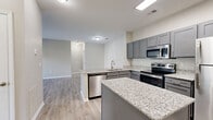 Located at 961 Seven Oaks Blvd in Smyrna, Tennessee, this two-bedroom, two-bathroom single-story residence offers a well-designed layout with modern finishes throughout. The open-concept kitchen and living area serves as the heart of the home, featuring gray shaker-style cabinetry, granite countertops, stainless steel appliances including a dishwasher, microwave, and range, and a peninsula island ideal for casual dining or meal prep. Light-toned luxury vinyl plank flooring runs through the main living areas, complementing the neutral wall palette and creating a clean, cohesive aesthetic. A dedicated dining room sits adjacent to the kitchen, offering a defined space for meals. The living room flows naturally from the kitchen, providing an open and airy feel. Both bedrooms are carpeted and generously sized, with the primary bedroom featuring a ceiling fan and two closets. The walk-in closet includes wire shelving for organized storage. A second bedroom offers a large window with neighborhood views and a ceiling fan. Each bathroom is appointed with granite-topped vanities and gray cabinetry consistent with the kitchen design. The laundry area is equipped with a full-size washer and dryer. With five closets throughout, storage is a clear priority in this thoughtfully planned Smyrna residence.