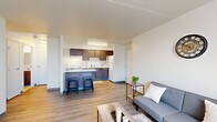 Located at 125 E 156th St in Cleveland, Ohio, this one-bedroom, one-bathroom unit offers a thoughtfully organized layout across a single floor. Light-toned wood-look flooring flows continuously throughout the space, creating a cohesive and clean aesthetic.

The living room features neutral white walls, a large window with vertical blinds that allows natural light to fill the room, and an exterior view of the surrounding neighborhood. The open feel of the space makes it versatile for various furniture arrangements.

The kitchen is efficiently designed with rich dark-toned cabinetry, both upper and lower, paired with white countertops and a white range. The kitchen opens to the main living area, promoting an easy flow between spaces.

The bedroom is a comfortable size, outfitted with the same wood-look flooring and bright white walls. A window with vertical blinds provides natural light and ventilation, while the clean, minimal design of the room offers a calm and restful environment.

The full bathroom is well-appointed with classic white tile flooring, a dark wood vanity with a white countertop and integrated sink, a mirror, and a bathtub with a cheerful striped shower curtain in soft tones of blue, pink, and beige. The overall design of the space is clean, modern, and move-in ready.