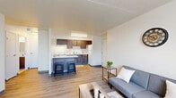 Located at 125 E 156th St in Cleveland, Ohio, this one-bedroom, one-bathroom unit offers a thoughtfully organized layout across a single floor. Light-toned wood-look flooring flows continuously throughout the space, creating a cohesive and clean aesthetic.

The living room features neutral white walls, a large window with vertical blinds that allows natural light to fill the room, and an exterior view of the surrounding neighborhood. The open feel of the space makes it versatile for various furniture arrangements.

The kitchen is efficiently designed with rich dark-toned cabinetry, both upper and lower, paired with white countertops and a white range. The kitchen opens to the main living area, promoting an easy flow between spaces.

The bedroom is a comfortable size, outfitted with the same wood-look flooring and bright white walls. A window with vertical blinds provides natural light and ventilation, while the clean, minimal design of the room offers a calm and restful environment.

The full bathroom is well-appointed with classic white tile flooring, a dark wood vanity with a white countertop and integrated sink, a mirror, and a bathtub with a cheerful striped shower curtain in soft tones of blue, pink, and beige. The overall design of the space is clean, modern, and move-in ready.