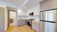 Located at 1257 N Detroit St. in the heart of West Hollywood, CA, this thoughtfully designed one-bedroom, two-bathroom unit offers a modern and efficient living experience across a single floor. Light-toned hardwood flooring flows throughout the main living areas, lending warmth and continuity to the space.

The kitchen is a standout feature, equipped with stainless steel appliances including a gas range, built-in microwave, and full-size refrigerator. Cabinetry combines crisp white upper cabinets with natural wood-toned lower cabinets, complemented by a marble-look tile backsplash and clean countertops — creating a stylish and functional cooking environment. Recessed lighting and a ceiling fan add comfort to the open living area adjacent to the kitchen.

The bedroom is a bright, clean space with smooth white walls, light wood flooring, and a window that allows natural light to filter in. Two bathrooms serve the unit: one features a soaking tub with a tiled surround, a wood-accented vanity, and light tile flooring; the second is a well-appointed full bath. Both bathrooms are finished in a neutral, contemporary palette. Warm-toned wood doors with modern hardware add a refined touch throughout. The overall ambiance is clean, minimalist, and move-in ready.