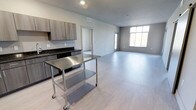 This 2-bedroom, 2-bathroom Type F residence offers a thoughtfully designed single-floor layout with a clean, modern aesthetic. The open-concept living area is anchored by light wood-toned luxury vinyl flooring that flows seamlessly throughout the space, creating a cohesive and airy atmosphere. A large window in the living area invites abundant natural light, enhancing the sense of openness and space.

The kitchen features dark granite countertops that contrast elegantly with taupe wood-grain cabinetry, providing ample storage and workspace. Stainless steel appliances complete the contemporary kitchen setup, adding a polished, professional feel to the cooking area. The kitchen opens directly to the expansive living space, making it ideal for both everyday living and entertaining.

The unit's neutral gray-toned walls and recessed lighting contribute to a bright, modern interior that serves as a versatile backdrop for any décor style. Two well-proportioned bedrooms and two full bathrooms offer comfortable, private accommodations. The overall layout is efficient and functional, making excellent use of the available square footage while maintaining a spacious feel throughout.
