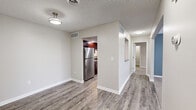Located at 2301 W Lexington Ave in Elkhart, Indiana, this single-floor residence offers a thoughtfully designed layout with a clean, modern aesthetic throughout. The main living area features durable wood-look vinyl flooring and neutral-toned walls, creating a bright and welcoming atmosphere. A central hallway connects the key areas of the home, providing an efficient and organized flow.

The kitchen is equipped with stainless steel appliances, including a refrigerator and electric range, complemented by rich dark wood cabinetry and granite-look countertops. The space is well-lit and functional, with ample storage provided by the upper and lower cabinets.

A standout feature of the home is a vaulted-ceiling room showcasing a striking arched window that floods the space with natural light, paired with a ceiling fan for comfort. The remaining bedrooms are carpeted and generously sized, each offering good natural light through blinded windows. One bedroom features dual closets with built-in shelving, providing excellent storage capacity, while another includes a single reach-in closet.

The bathrooms are finished with granite-topped dark wood vanities and brushed nickel hardware. One bathroom includes a tub-shower combo, while another is equipped with an accessibility grab bar. Wood-look vinyl flooring ties these spaces together with the rest of the home's cohesive design.
