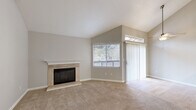Located at 7952 Pocket Rd in Sacramento's Pocket neighborhood, this one-bedroom, one-bathroom unit offers a well-designed single-floor layout with a comfortable and functional living space. The living room is a standout feature, boasting soaring vaulted ceilings that amplify the sense of openness and airiness. A tile-surround fireplace with a crisp white mantle serves as the room's focal point, while plush wall-to-wall carpet, neutral tones, and a sliding glass door with vertical blinds contribute to a warm, inviting ambiance. Natural light filters in through multiple windows fitted with blinds. The kitchen has been thoughtfully updated with white shaker-style cabinetry, a herringbone tile backsplash, gray quartz countertops, stainless steel appliances including a gas range and refrigerator, and a peninsula with an undermount sink — ideal for casual dining or meal prep. A hallway connects the main living areas to the spacious bedroom, which features soft carpeting, a natural light window, and access to a dedicated closet. The bathroom is finished with wood-look flooring, a white vanity with quartz countertop, a large mirror, and a tub/shower combination. The entry area offers additional storage with a built-in closet unit.