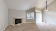 Located at 7952 Pocket Rd in Sacramento's Pocket neighborhood, this one-bedroom, one-bathroom unit offers a well-designed single-floor layout with a comfortable and functional living space. The living room is a standout feature, boasting soaring vaulted ceilings that amplify the sense of openness and airiness. A tile-surround fireplace with a crisp white mantle serves as the room's focal point, while plush wall-to-wall carpet, neutral tones, and a sliding glass door with vertical blinds contribute to a warm, inviting ambiance. Natural light filters in through multiple windows fitted with blinds. The kitchen has been thoughtfully updated with white shaker-style cabinetry, a herringbone tile backsplash, gray quartz countertops, stainless steel appliances including a gas range and refrigerator, and a peninsula with an undermount sink — ideal for casual dining or meal prep. A hallway connects the main living areas to the spacious bedroom, which features soft carpeting, a natural light window, and access to a dedicated closet. The bathroom is finished with wood-look flooring, a white vanity with quartz countertop, a large mirror, and a tub/shower combination. The entry area offers additional storage with a built-in closet unit.