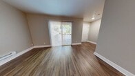 Located at 15267 Hesperian Blvd in San Leandro, California, this single-floor residence offers a clean, modern aesthetic with a thoughtful layout throughout. The main living area is finished with warm, wood-style vinyl plank flooring and neutral taupe walls, creating a bright and welcoming atmosphere. A full-length sliding glass door fitted with vertical blinds fills the space with natural light and provides views of the surrounding greenery, while a dedicated entryway with a paneled front door offers a clear sense of arrival.

The kitchen is well-appointed with crisp white shaker-style cabinetry, light stone-finish countertops, and stainless steel appliances including an electric range and an over-the-range microwave, making it both functional and visually clean.

The bedrooms are carpeted for comfort and feature large windows that invite natural light and outdoor views of mature trees. Each bedroom includes baseboard heating and ample wall space, providing flexible furniture arrangements. The neutral color palette carried throughout the unit lends a cohesive, move-in-ready feel. Clean white baseboards and recessed lighting in select areas complete the polished, well-maintained character of this single-level residence.