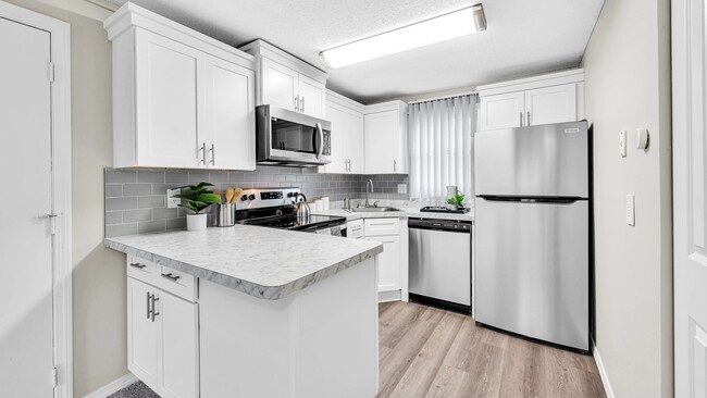 Cherish our stunning, renovated kitchens featuring Carrara-style countertops and wood-style flooring. - Sugarloaf Estates