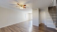 Located at 2001 Slayden St in Brownwood, Texas, this two-story home offers a practical and comfortable layout spread evenly across two floors. The main level features durable hardwood-style flooring throughout the open living area, which is equipped with a ceiling fan and light fixture. Natural light filters in through windows near the entryway, creating a welcoming atmosphere. The kitchen is well-appointed with warm wood cabinetry, tile-accented countertops, a double-basin sink, and white appliances including a refrigerator, dishwasher, and range. A dedicated laundry area with shelving is conveniently located adjacent to the kitchen. A full bathroom on the main level includes a wood-toned vanity with a stone-look countertop and a bathtub. The second floor hosts both bedrooms, each finished with plush carpet and ceiling fans. The spacious primary bedroom offers generous room to furnish, while the secondary bedroom features a large window that allows natural light to brighten the space. Both bedrooms are served by multiple closets, with six closets total throughout the home. A second full bathroom is also located upstairs. The home additionally includes a private patio, providing outdoor space for relaxation.