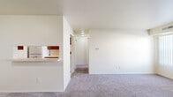 This single-floor, one-bedroom, one-bathroom unit in Fort Gratiot, Michigan, offers a practical and well-organized layout designed to maximize everyday functionality. The living area is generously proportioned, featuring soft wall-to-wall carpeting, neutral cream-toned walls, and two large windows dressed with vertical blinds that allow natural light to fill the space. The open sightlines from the living area extend through a central hallway, creating a connected and airy feel throughout.

The galley-style kitchen is efficiently designed with rich medium-toned wood cabinetry lining both walls, offering ample upper and lower storage. Light countertops provide workspace alongside a stainless steel sink, and white appliances — including a refrigerator, electric coil range, and dishwasher — complete the setup. Tile flooring runs throughout the kitchen, adding durability. A pass-through breakfast bar connects the kitchen to the living area, enhancing the open flow of the unit.

The bedroom is a comfortable, carpet-floored retreat illuminated by two windows with vertical blinds, providing natural light and outdoor views. The full bathroom includes a single-sink vanity with wood cabinetry, a large mirror, light tile flooring, and a tub-shower combination with white tile surround. Overall, the unit presents a clean, neutral palette suited for easy personalization.