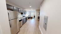 Located at 168 Bass Pro Dr in Sevierville, Tennessee, this single-floor unit offers a practical and modern layout across five distinct areas. Light hardwood-style flooring runs throughout, creating a cohesive and clean aesthetic from room to room.

The kitchen is a standout feature, outfitted with dark-toned cabinetry, white countertops, and a full suite of stainless steel appliances including a refrigerator, range, microwave, and dishwasher. Recessed lighting illuminates the space effectively, and the open design allows the kitchen to flow naturally into the living area.

The living room is compact yet functional, featuring a window with blinds that brings in natural light and offers views of the surrounding area. A sofa with ottoman, flat-screen TV, and decorative wall accents complete the space.

The bedroom is quietly appointed with a window allowing natural light, a walk-in closet for ample storage, and warm, neutral tones throughout. Rustic wood furniture accents add character to the room.

The bathroom features light hardwood-style flooring, a shower with curtain, a vanity with dark cabinetry, and a well-lit mirror. The overall design of the unit is modern, neutral, and move-in ready.