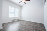 Located at 2515 Gaston Rd in Cottage Grove, WI, this single-floor, one-bedroom, one-bathroom unit offers a thoughtfully designed layout that makes efficient use of its compact footprint. The interior features a clean, modern aesthetic with neutral tones and crisp white walls throughout, creating a bright and inviting atmosphere.

The open living and kitchen area is finished with durable wood-look luxury vinyl plank flooring, pendant lighting, and a window dressed with gray curtains that allows natural light to fill the space. The kitchen includes dark-stained cabinetry paired with a white countertop and a single-basin sink.

The generously sized primary bedroom features soft carpeting, a high clerestory window for added natural light, and a baseboard heating unit. It is complemented by two dedicated closets — one of which is a walk-in closet outfitted with wire shelving systems for organized storage.

The bathroom is well-appointed with wood-look tile flooring, a dark-cabineted vanity with a white countertop, a large mirror, a baseboard heater, and a toilet. The hallway connecting the rooms also features wood-look flooring and provides a smooth transition between spaces. A recessed electrical panel is conveniently integrated into the utility area. Overall, this unit delivers a modern, functional living environment in a clean and well-maintained setting.
