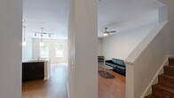 Located at 2101 Arlington Blvd in Charlottesville, VA, this two-story, 2-bedroom, 4-bathroom unit is thoughtfully laid out across two floors. The main level hosts a combined kitchen and living area, where warm hardwood-style flooring runs throughout. The kitchen is a standout feature, equipped with dark espresso cabinetry, granite countertops, stainless steel appliances including a refrigerator, range, and microwave, and a peninsula with pendant lighting and bar seating — ideal for casual dining. The open living area is brightened by natural light from nearby windows and features a ceiling fan overhead, with a staircase leading to the upper level. The bedrooms offer plush carpeting and a calm, neutral palette, with the primary bedroom providing a comfortable and private retreat. Four full bathrooms serve the unit, each finished with dark vanity cabinetry, white countertops, and tub/shower combinations with hardwood-style flooring. Two closets provide ample storage throughout the home. The clean, neutral tones and consistent modern finishes give the entire space a cohesive and functional aesthetic.