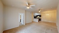 This single-story home in Baton Rouge, Louisiana offers a practical and well-organized layout across four bedrooms and two full bathrooms. The open living and dining area forms the heart of the home, finished with light-toned carpeting and multiple ceiling fans that promote comfortable airflow. A chandelier accents the dining zone, adding a subtle decorative touch, while a hallway connects seamlessly to the bedroom wing.

The kitchen is designed for functionality, featuring dark espresso cabinetry, light countertops, and black appliances including a refrigerator and range. Tile flooring runs throughout the kitchen, providing a clean contrast to the carpeted living spaces. A peninsula counter opens toward the main living area, encouraging an easy flow between cooking and entertaining spaces.

Each bedroom is carpeted, benefits from a ceiling fan with light, and receives natural light through windows with blinds. The bedrooms offer a calm, neutral atmosphere with clean white walls and consistent finishes.

Both bathrooms are outfitted with dark vanity cabinetry, light countertops, and tile flooring. One bathroom includes a tub-shower combination, while the second bath provides a straightforward layout with a vanity and toilet. The overall design is consistent and practical throughout the home.