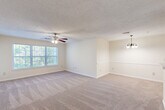 Located at 50 Carrington Ln in Douglasville, GA, this 2-bedroom, 1-bathroom single-story home offers a practical and comfortable layout. The open-concept living room is generously sized, featuring plush wall-to-wall carpeting, a ceiling fan with light fixture, textured ceilings, and large windows that invite abundant natural light and views of surrounding greenery. An elegant chandelier marks the transition toward the dining and kitchen area.

The kitchen is designed for functionality, featuring warm wood-toned cabinetry, a peninsula countertop with a built-in sink, white appliances including a refrigerator and electric range, and durable wood-look flooring that contrasts the carpeted living spaces.

Both bedrooms are comfortably proportioned with plush carpeting, ceiling fans, and windows offering natural light and outdoor views. The primary bedroom is notably spacious and includes access to a dedicated closet. A second closet provides additional storage elsewhere in the home.

The full bathroom is clean and straightforward, featuring a tiled shower-tub combination, wood-look flooring, and classic fixtures. Hallways connect the rooms efficiently throughout the single-floor layout, making the home easy to navigate. Overall, the space presents a bright, neutral palette well-suited for comfortable everyday living.