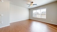 This single-story, 3-bedroom, 2-bathroom home in Tulsa, Oklahoma offers a practical and well-designed layout across a comfortable footprint. Warm wood-look flooring flows consistently throughout the home, complementing the neutral gray tones on the walls and crisp white trim and baseboards. The living room is a bright, open space featuring a ceiling fan and large windows that allow natural light to fill the room while providing views of the surrounding neighborhood. An adjacent dining area connects seamlessly to the kitchen, which is equipped with dark espresso cabinetry, light countertops, a kitchen island, black appliances including a range, dishwasher, and over-the-range microwave, and a double-basin sink. The primary bedroom offers generous space with vaulted ceilings, a ceiling fan, a double-door closet, and access to the hallway. The two additional bedrooms each feature ceiling fans, large windows, and wood-look flooring, making them well-suited for various uses. Both bathrooms are finished with dark vanity cabinetry, white countertops, large mirrors, and hardwood-style flooring, with one bathroom featuring accessibility grab bars. A dedicated laundry room and an impressive eight closets throughout the home provide exceptional storage. This home delivers a clean, move-in-ready atmosphere with functional design details throughout.
