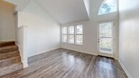 Located at 499 Northside Cir NW in Atlanta's 30309 zip code, this two-bedroom, two-bathroom home spans two floors, offering a well-organized and functional layout. The main level houses the entrance, living room, dining area, and kitchen, while the upper level is dedicated to the bedrooms and bathrooms.

The living room immediately impresses with soaring vaulted ceilings, wood-style flooring, and a striking arched window alongside a glass door that floods the space with natural light. The open-concept kitchen features dark espresso cabinetry, granite countertops with a breakfast bar overhang, stainless steel appliances including a refrigerator and microwave, pendant lighting, and a tile backsplash — all complemented by light wood-style flooring.

Upstairs, the generously sized primary bedroom offers plush carpeting, ample closet space, and direct access to a bathroom. The second bedroom, also carpeted with a textured ceiling, receives natural light through a window with blinds. Both bathrooms are clean and functional, with one featuring a full soaking tub and shower combination with chrome fixtures.

Throughout the home, white walls and bright finishes create a light, airy ambiance, while four closets and a dedicated hallway enhance everyday practicality.