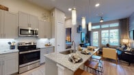 This well-appointed single-floor residence blends modern design with warm, eclectic character. The open-concept kitchen is a standout, featuring granite countertops, a large center island with bar seating, soft-close gray shaker cabinetry extending to the ceiling, under-cabinet lighting, a full suite of stainless steel appliances, and elegant pendant lighting overhead. The kitchen flows seamlessly into the living area, where light hardwood-style flooring, a striking whitewashed brick accent wall, and tall doors opening to an outdoor balcony create a bright, inviting atmosphere. Floor-to-ceiling windows flood the living space with natural light and offer views of the surrounding area. Both bedrooms are generously proportioned, carpeted for comfort, and feature large windows with outdoor views. Each connects to its own bathroom, which includes granite-topped gray vanities, wood-look flooring, and either a glass-enclosed shower or a tub-shower combination. The overall ambiance is contemporary yet cozy, with a cohesive neutral palette punctuated by thoughtful design details throughout every room.