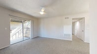 Located at 1448 Adriel Lane in Orlando, FL, this 2-bedroom, 2-bathroom residence offers a thoughtfully laid-out single-floor plan designed for comfortable everyday living. The living room is bright and welcoming, featuring plush carpet, a ceiling fan, and sliding glass doors that open directly onto a covered balcony, bringing in natural light and outdoor views. An adjoining dining area with a pendant light fixture flows seamlessly into the kitchen, which is outfitted with warm honey-toned wood cabinetry, granite-style countertops, a kitchen island, hardwood flooring, and white appliances including a refrigerator, range, and dishwasher — all lit by a window above the sink. Both bedrooms are carpeted and include ceiling fans; the primary bedroom offers a generous footprint with a closet, while the second bedroom features a window with outdoor views. The two bathrooms are consistently appointed with rich wood vanities, granite-style countertops, framed mirrors, and tub-shower combinations over hardwood flooring. A dedicated laundry room houses a full-sized washer and dryer. With a hallway connecting all spaces and ample closet storage, this residence balances practicality with a clean, neutral aesthetic throughout.