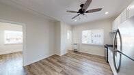 Located at 2025 East 4th St in the East Los Angeles neighborhood of 90033, this single-floor unit has been thoughtfully updated with contemporary finishes throughout. The interior is unified by warm wood-look luxury vinyl flooring that runs seamlessly from room to room, complemented by crisp white walls and clean white baseboards that lend a bright, fresh atmosphere.

The kitchen stands out as a central highlight, featuring white Shaker-style cabinetry that reaches toward the ceiling, a classic white subway tile backsplash, dark countertops, and a full suite of stainless steel appliances including a gas range and a full-size refrigerator. A ceiling fan with integrated lighting and recessed lighting overhead keep the space well-lit and comfortable.

The living area is open and inviting, with a ceiling fan, recessed lighting, and windows fitted with horizontal blinds that allow natural light to filter in. A wall-mounted heating unit provides climate control. The bedroom benefits from its own ceiling fan and a generous window framing views of the surrounding neighborhood, including glimpses of palm trees that speak to the Southern California setting.

The bathroom presents a clean, modern aesthetic with marble-look tile surrounding the bathtub and shower, a bright window for natural ventilation, and contemporary brushed nickel fixtures and towel bars. The overall design of this unit is cohesive, practical, and move-in ready.